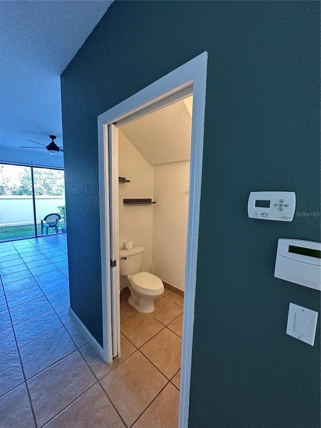 bathroom featuring ceiling fan, tile patterned floors, a textured ceiling, and toilet