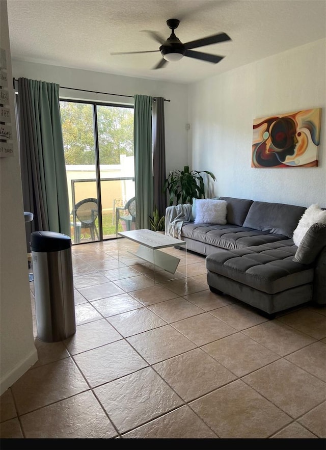 living room with ceiling fan, light tile patterned flooring, and a textured ceiling