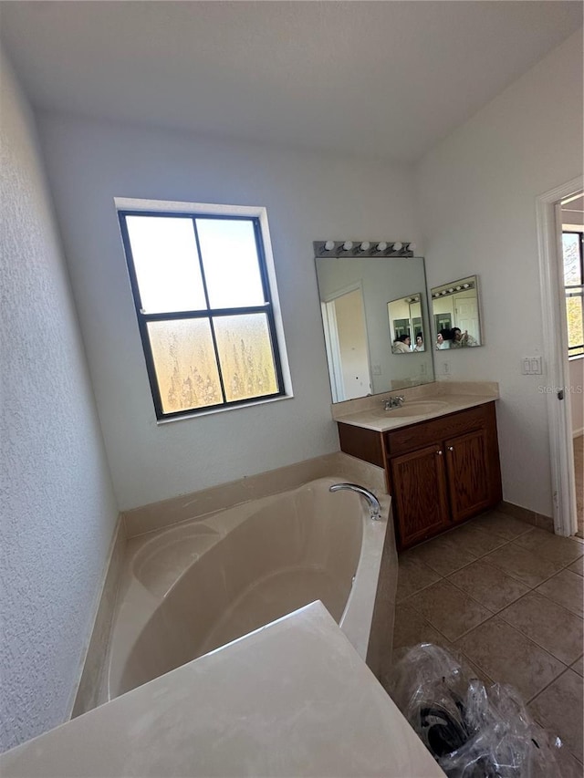 bathroom with vanity, a bath, and tile patterned flooring