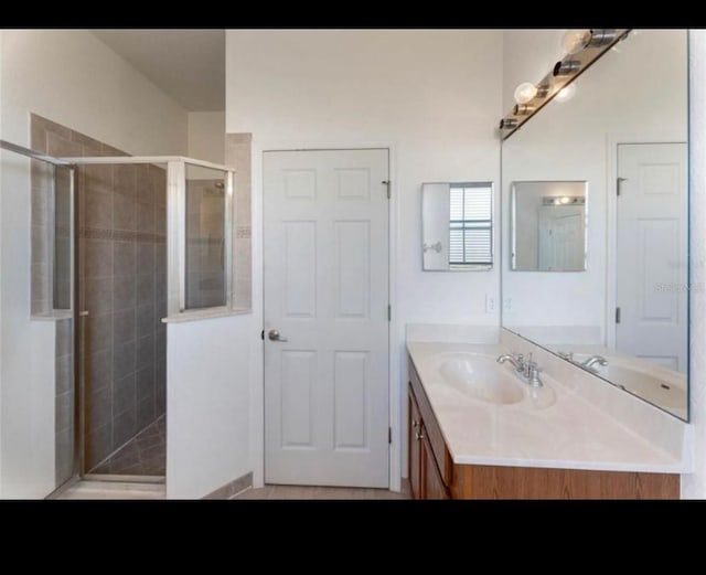 bathroom with vanity and a shower with door