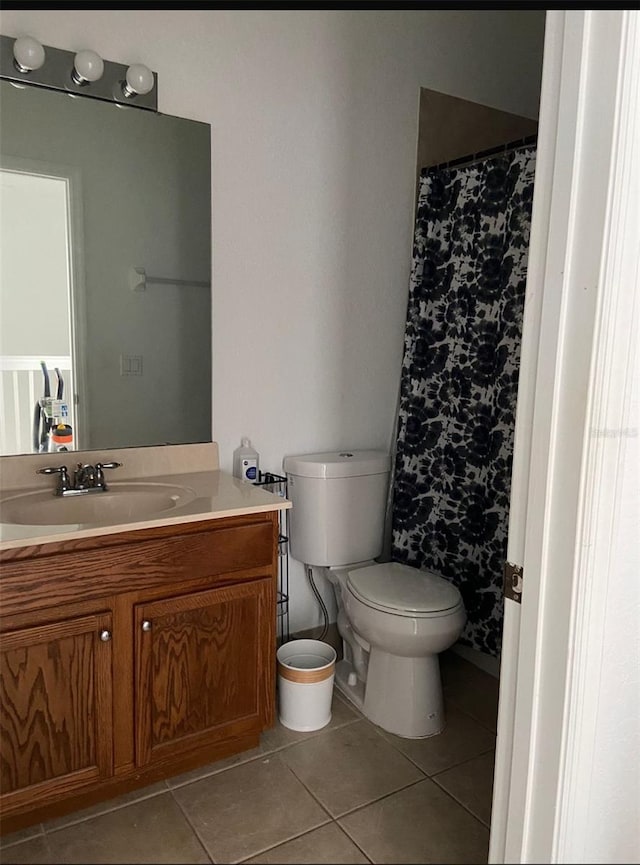 bathroom with tile patterned flooring, vanity, and toilet