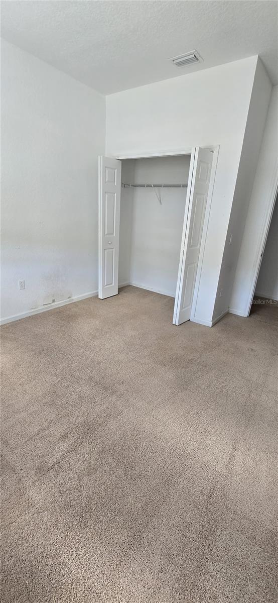 unfurnished bedroom with a closet, carpet flooring, and a textured ceiling