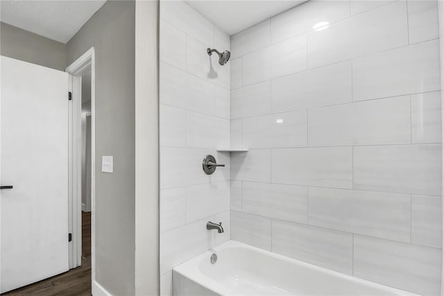 bathroom featuring tiled shower / bath combo and hardwood / wood-style flooring