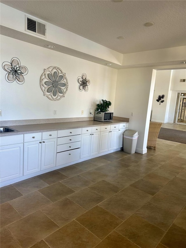 interior space featuring sink and a textured ceiling