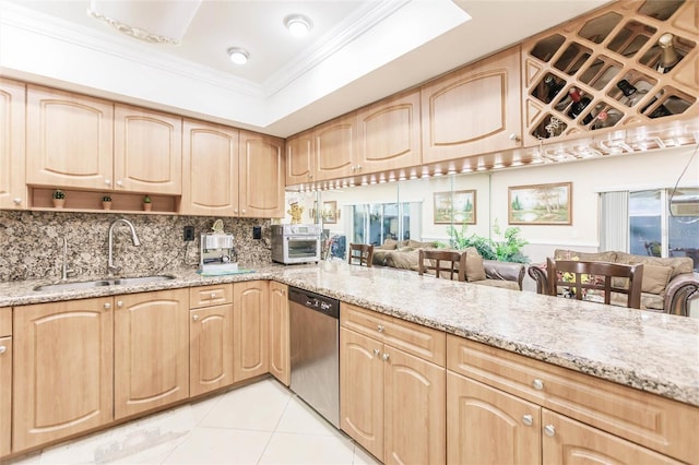 kitchen with light brown cabinetry, sink, stainless steel dishwasher, light stone countertops, and backsplash