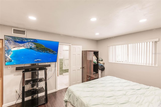 bedroom with multiple windows, ensuite bathroom, and wood-type flooring