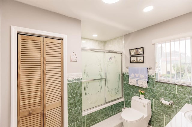 bathroom with enclosed tub / shower combo, tile walls, tile patterned floors, and toilet