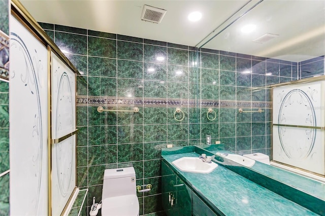 bathroom with tile walls, vanity, and toilet