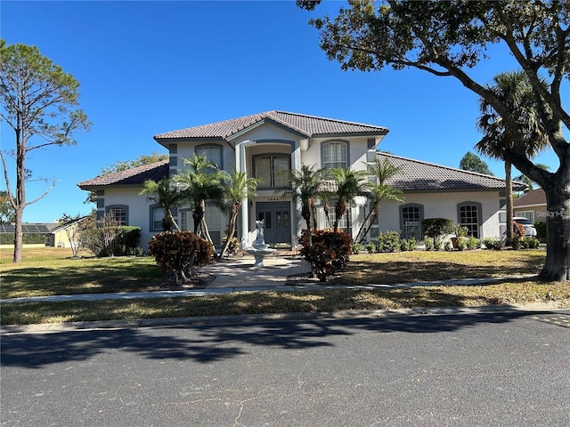 mediterranean / spanish home featuring french doors and a front lawn