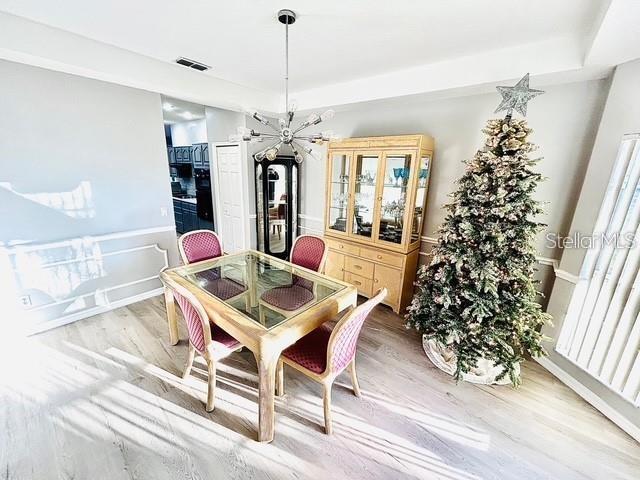 dining space featuring light hardwood / wood-style flooring and a tray ceiling