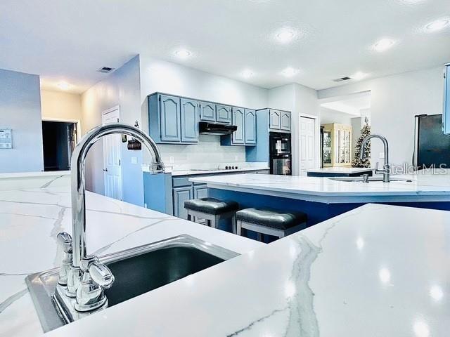 kitchen with sink, decorative backsplash, and black appliances