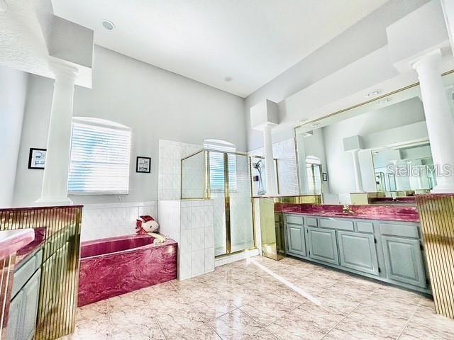 bathroom featuring vanity, plus walk in shower, and ornate columns