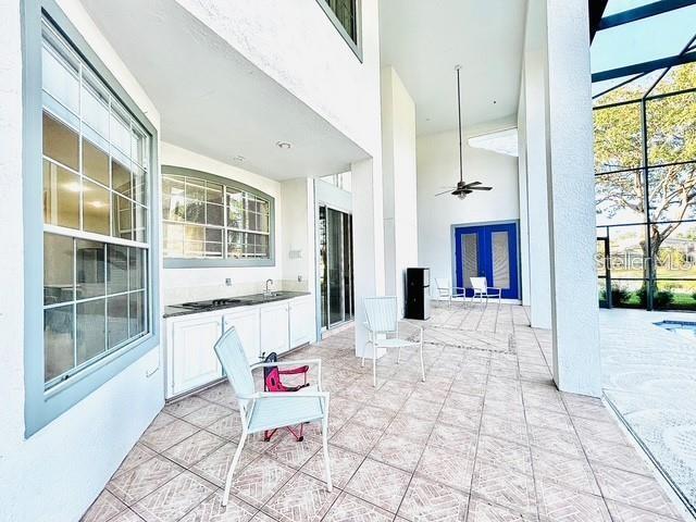 view of patio featuring ceiling fan and a lanai