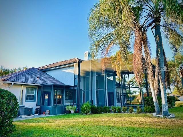 exterior space with cooling unit and a lawn