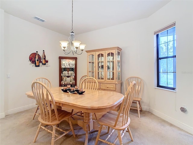 dining area with light carpet and an inviting chandelier