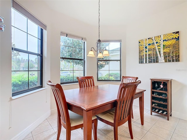 dining area with a healthy amount of sunlight, light tile patterned floors, and an inviting chandelier