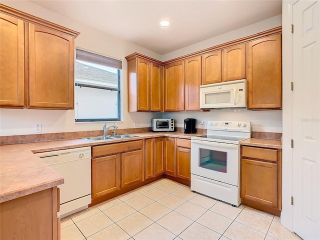 kitchen with light tile patterned flooring, white appliances, and sink