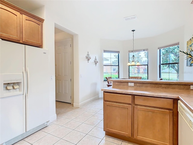 kitchen featuring light tile patterned floors, white appliances, and decorative light fixtures