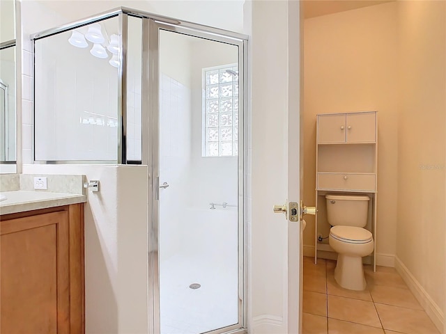 bathroom with vanity, a shower with shower door, tile patterned floors, and toilet