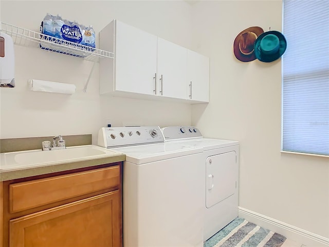 laundry room featuring separate washer and dryer, sink, and cabinets