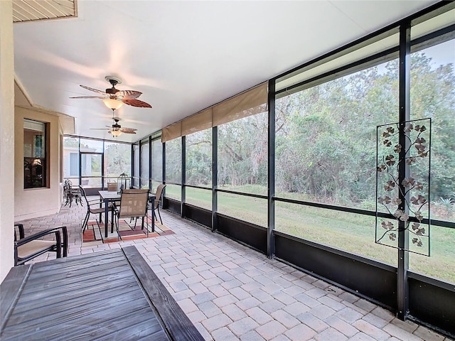 unfurnished sunroom featuring ceiling fan