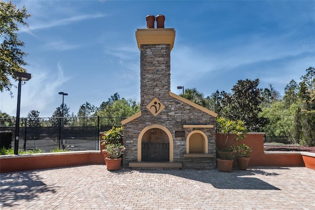 view of front of house with a patio and an outdoor stone fireplace