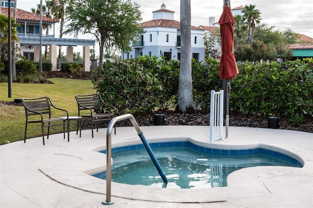 view of swimming pool with a yard and an in ground hot tub