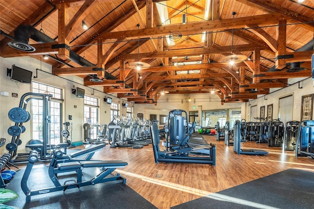 exercise room with wood-type flooring, high vaulted ceiling, and wooden ceiling