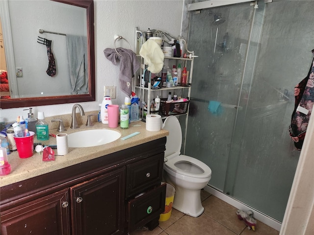 bathroom featuring vanity, toilet, an enclosed shower, and tile patterned flooring