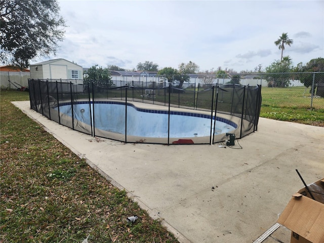 view of pool featuring a storage shed and a yard