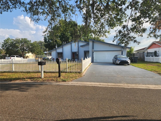 602 Caddy Dr, Kissimmee, FL 34759 - view of front of home featuring a fenced front yard, an attached garage, a front yard, and driveway