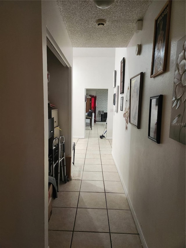 602 Caddy Dr, Kissimmee, FL 34759 - hallway featuring light tile patterned floors, baseboards, and a textured ceiling