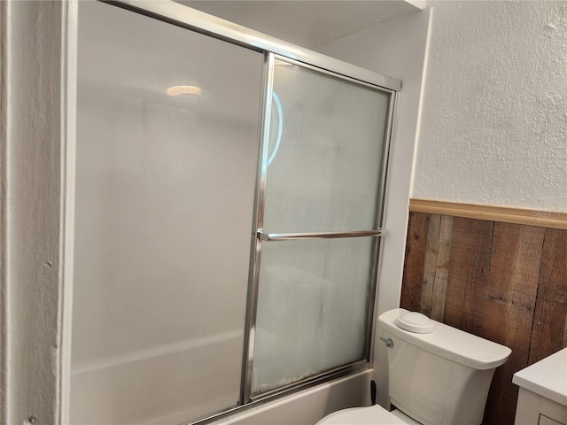 602 Caddy Dr, Kissimmee, FL 34759 - full bathroom featuring toilet, a wainscoted wall, vanity, a textured wall, and enclosed tub / shower combo