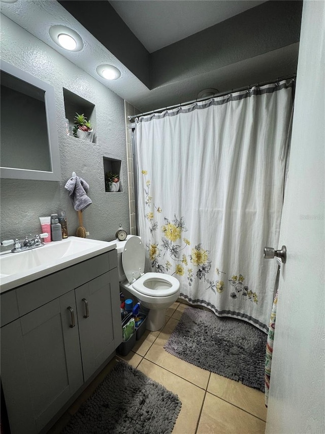 bathroom with a shower with curtain, vanity, toilet, and tile patterned flooring