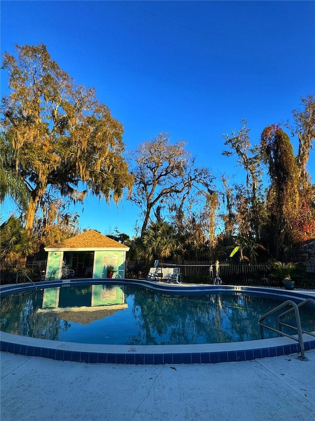 view of swimming pool featuring an outbuilding