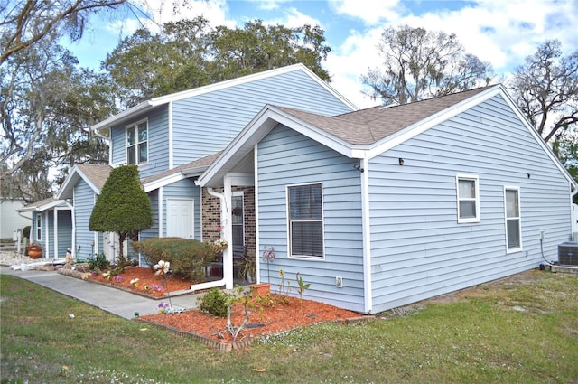 view of front of house with a front lawn and roof with shingles