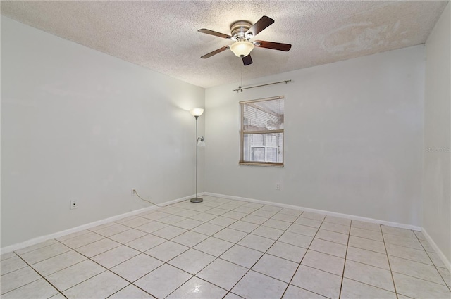 tiled empty room featuring ceiling fan and a textured ceiling