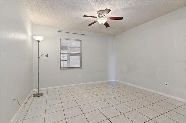 tiled empty room featuring ceiling fan and a textured ceiling