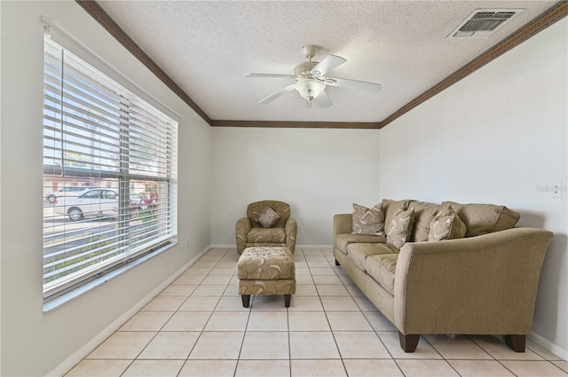 living room featuring light tile patterned flooring, ornamental molding, ceiling fan, and a textured ceiling