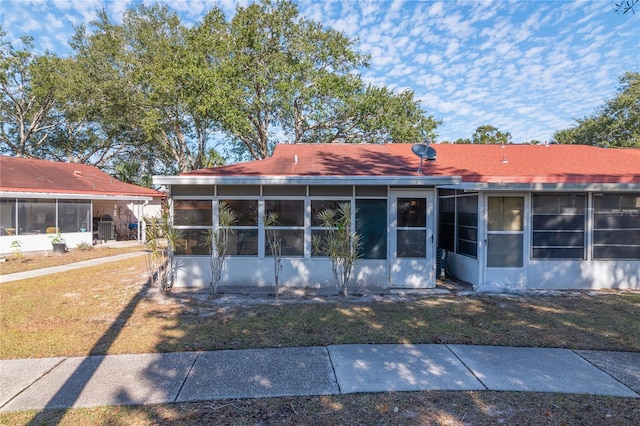 view of front facade featuring a front yard and a sunroom