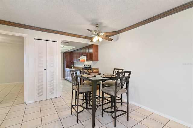 dining area featuring ornamental molding, light tile patterned floors, and a textured ceiling