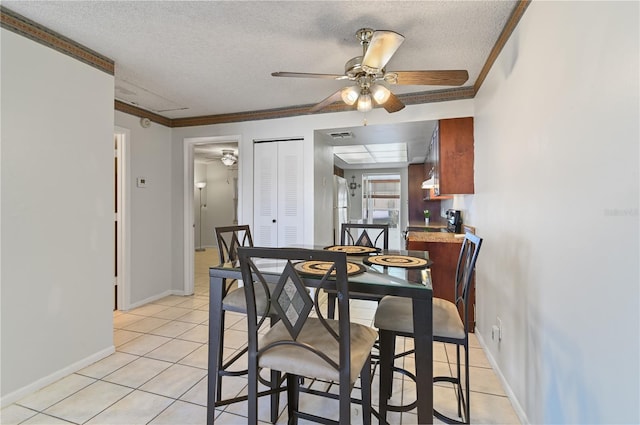 dining area with crown molding, light tile patterned floors, ceiling fan, and a textured ceiling