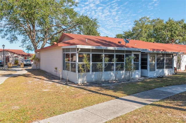 view of front of home featuring a front yard and a sunroom