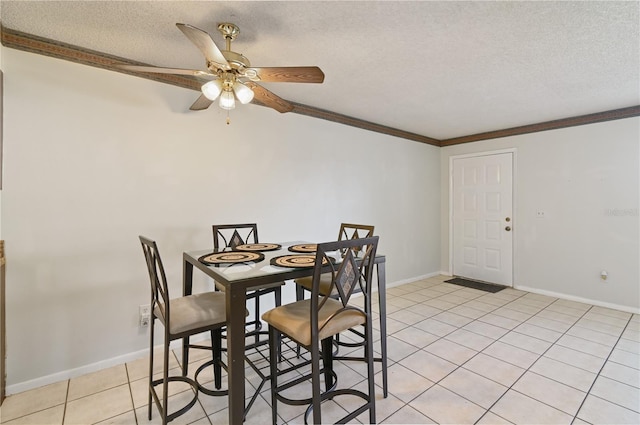 dining room with crown molding, ceiling fan, light tile patterned flooring, and a textured ceiling