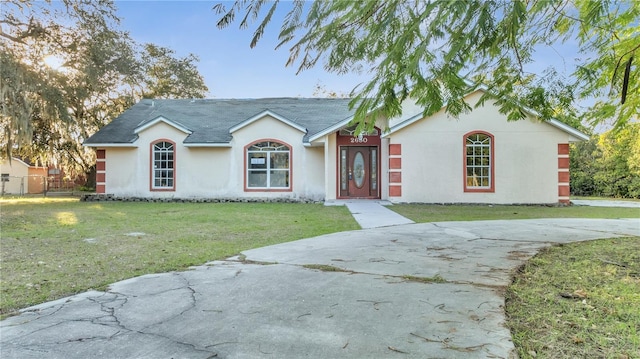 single story home featuring a front lawn