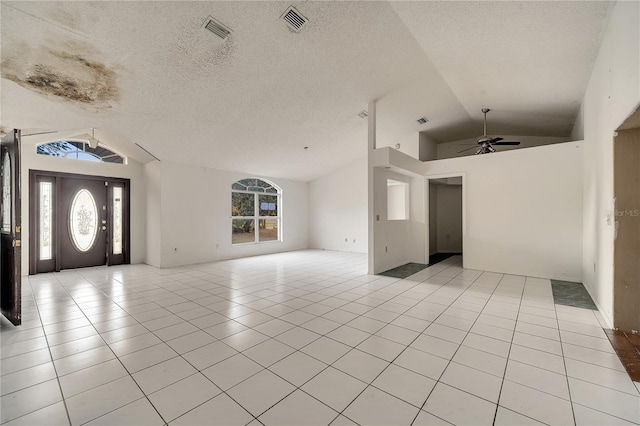 tiled foyer entrance featuring ceiling fan, vaulted ceiling, and a textured ceiling