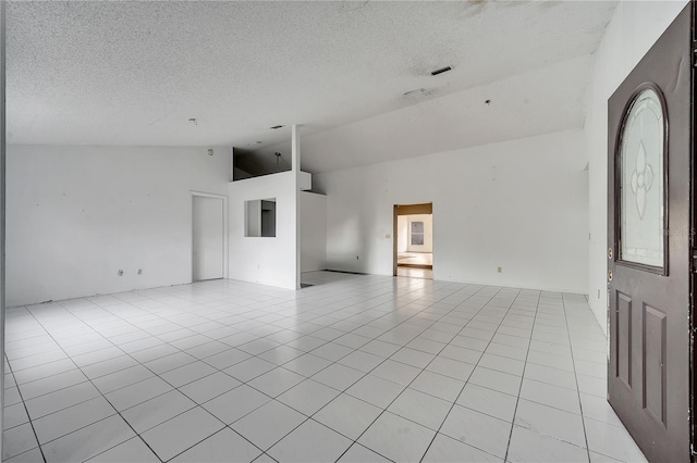 tiled spare room featuring a textured ceiling and high vaulted ceiling