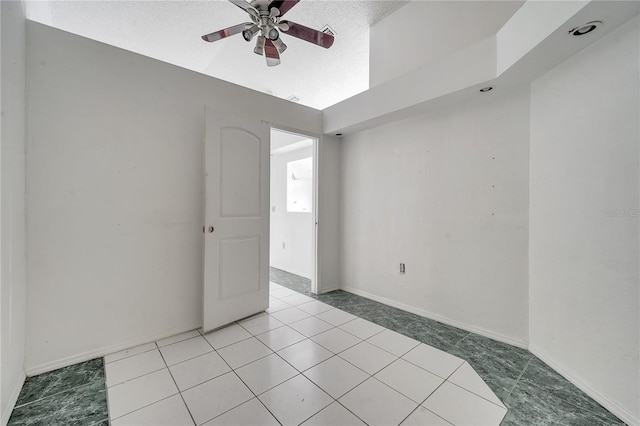 tiled spare room featuring ceiling fan and a textured ceiling