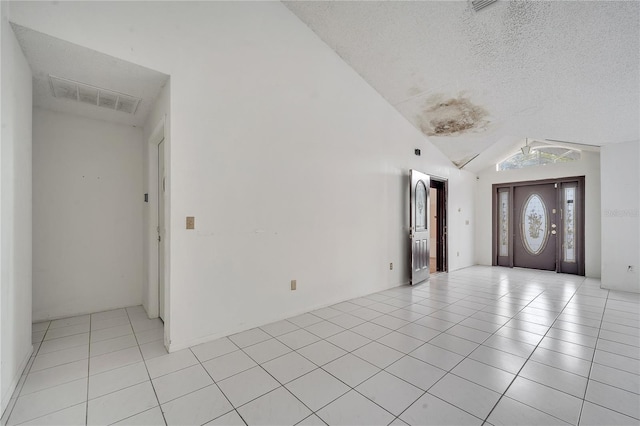 tiled foyer entrance with vaulted ceiling and a textured ceiling