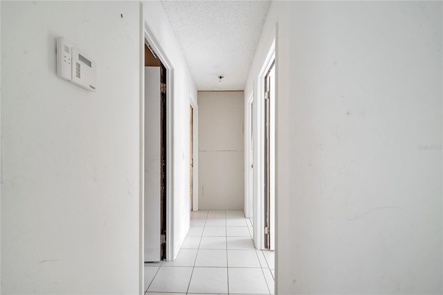 hallway with light tile patterned floors and a textured ceiling